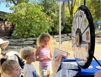 children at a table with a spinning wheel