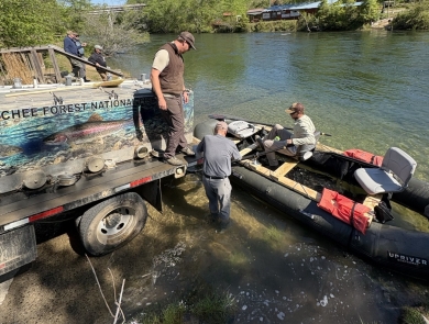 Service staff transfer trout from a stocking truck to a raft.