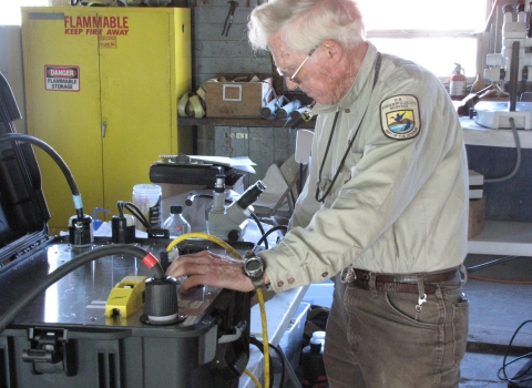 Kurt Steinke, an Electronics Engineer with the Abernathy Fish Technology Center adjusts an electroshocker's current and broadcast range as part of a study to control common carp densities at Malheur NWR Lake.