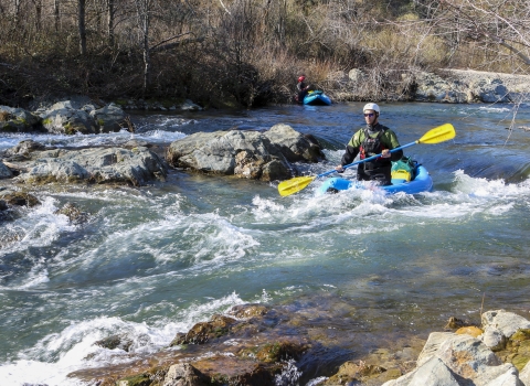 a man kayaks down a river in rapids