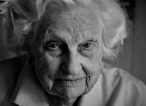 a black and white photo of an elderly woman lookin at the camera