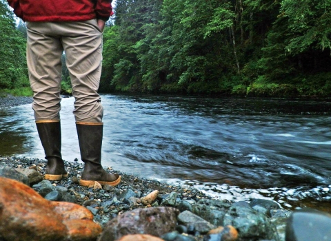 man standing by a river in rain gear