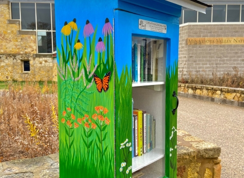 Little Free Library outside the Bloomington Visitor Center painted with native flowers.