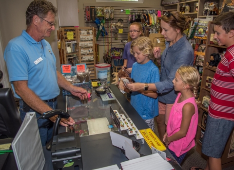 volunteer Wayne Allan helps visitors in Friends shop