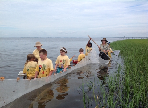 Children exploring Apalachee Bay. They are using a net to look for saltwater creatures.