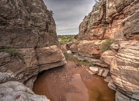 Cibola Canyon red and brown walls with water below