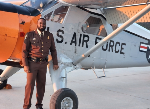 African American man stands in front of plane with "U.S.  AIR FORCE" on side