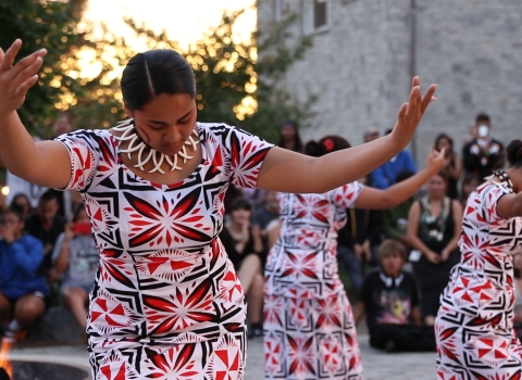 three American Samoa students performing a traditional dance in a circle