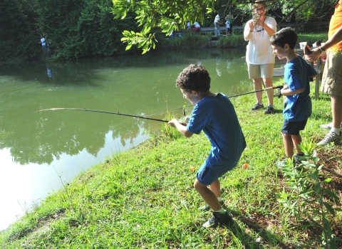 Two young brothers are fishing in the Sewee Pond at the annual Youth Fishing Rodeo.