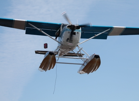 USFWS float plane dropping a package of supplies. Sometimes a plane can not land in a particular area, in which case an air drop may occur to supply the camp with food and other supplies that they might need. 