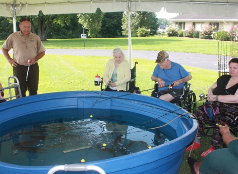 Nursing Home residents fishing out of a stock tank.