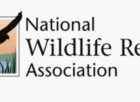 A logo with an image of a bird soaring over a marsh and the words National Wildlife Refuge Association next to it