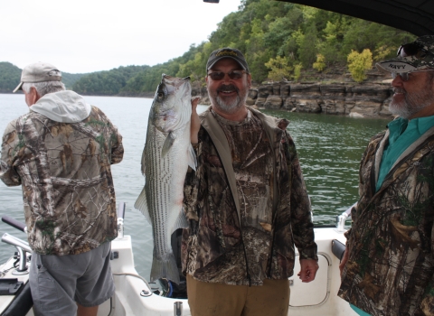 Wounded Warrior Fishing Derby participant holding striper