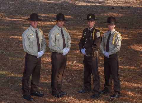 Four uniformed employees stand together.