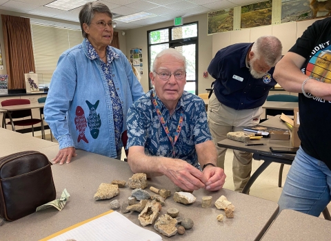 Professor examining fossils in a classroom