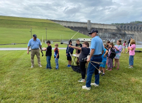 Kids and USFWS volunteers using shooting archery