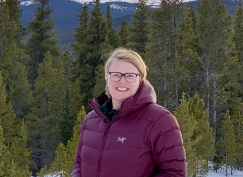 Nicole Alt with trees and mountains in the background