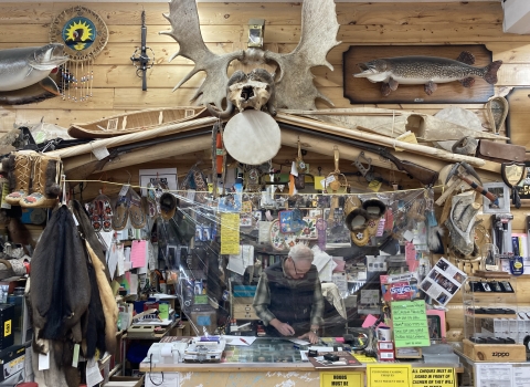 person working in an office with pelts and antlers and outdoor items all around