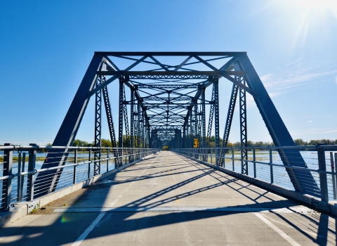 front view of a pedestrian, multi-span truss bridge on a sunny day