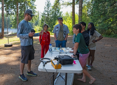 Jakob Bengelink teaching a fisheries science technology lesson around a table outside at the academy.
