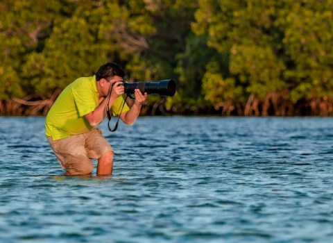 Ernesto Gomez in the field taking pictures in the water