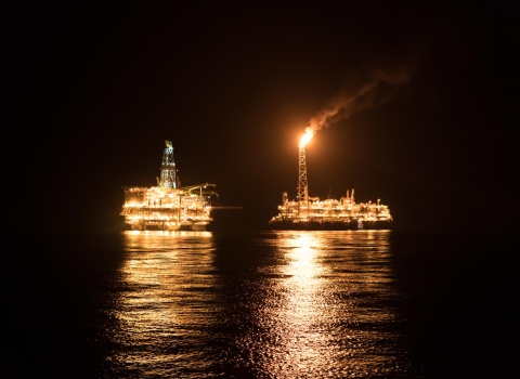 Two offshore vessels out at sea during the night with lights on