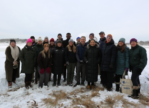 A smiling group stands in a frozen salt marsh