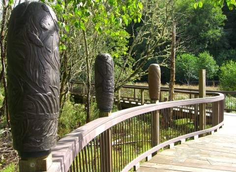 Carved posts along a boardwalk at Willapa National Wildlife Refuge show stages in the life cycle of a salmon.