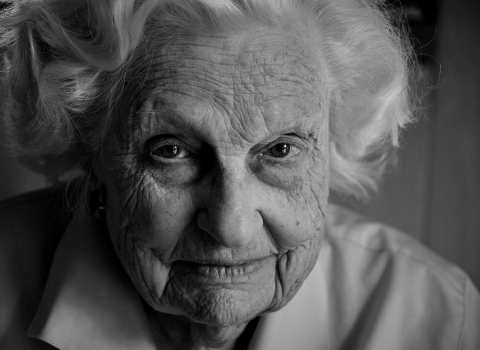 a black and white photo of an elderly woman lookin at the camera
