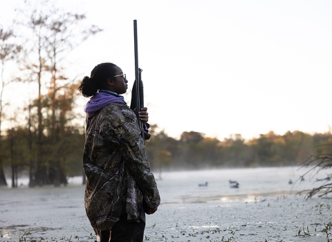 Young Woman In Hunting Gear Stands at Dusk-Wetlands