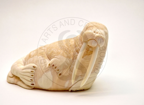 ivory carving of walrus with watermark reading Indian Arts and Crafts Board