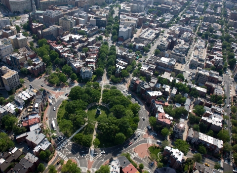 an aerial view of a city, with a circular layout in the middle. Trees engulf the circl