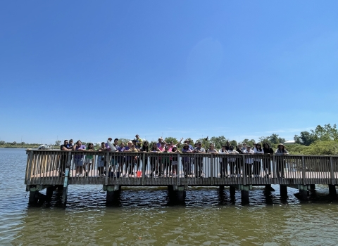 a group of people stand on a fishing pier