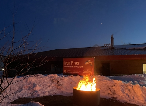 a fire in a fire ring in front of Iron River NFH sign