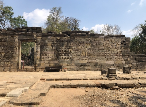 A stone wall with an open doorway and engraved images