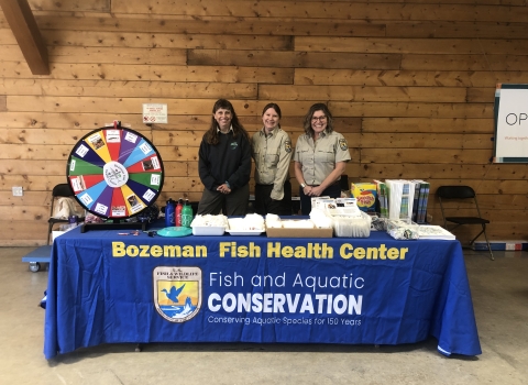 Biologists attend a table with education materials