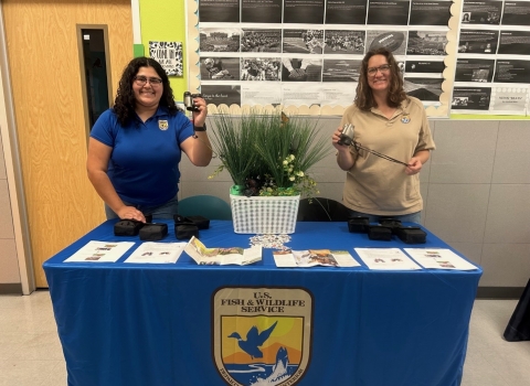 Two U.S. Fish and Wildlife Service field biologists standing behind a table at the Corpus Christi School of Science and Technology’s Gifted and Talented Spring Festival 