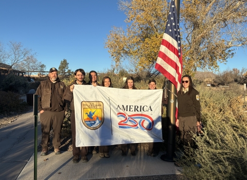 FWS staffers hold America 250-FWs flag as US flag flies