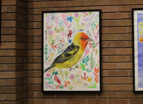 Two framed art pieces on a brick wall