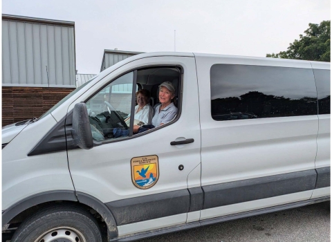 Image of two females in a USFWS van smiling at the viewer.
